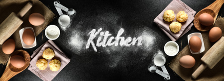 Kitchen text with kitchen utensils and baking ingredients: egg and flour on black background, copy-space.の写真素材