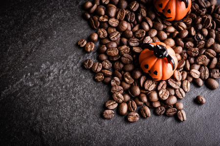 Halloween pumpkin decoration with coffee beans on dark backgroundの写真素材