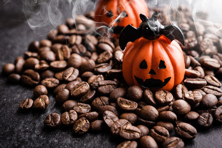 Halloween pumpkin decoration with coffee beans on dark backgroundの写真素材