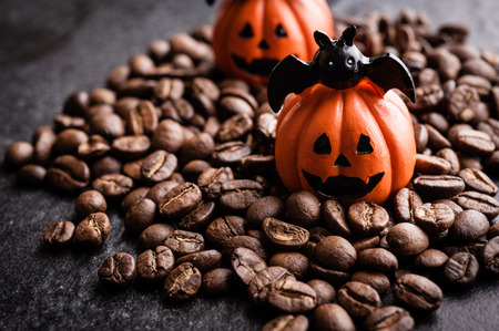 Halloween pumpkin decoration with coffee beans on dark backgroundの写真素材