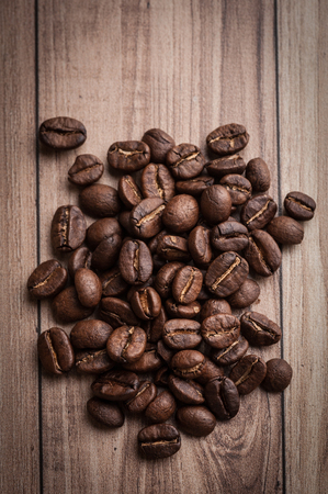 roasted coffee beans on wooden background, can be used as a backgroundの写真素材