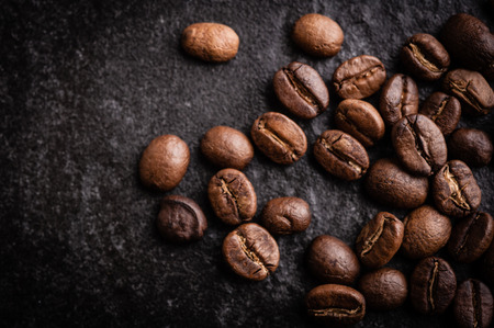 roasted coffee beans on dark background, can be used as a backgroundの写真素材