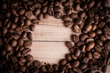 roasted coffee beans on wooden background, can be used as a backgroundの写真素材