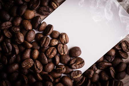 roasted coffee beans with black paper on wooden background, can be used as a backgroundの写真素材