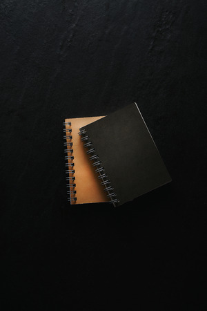 Modern note pad on black background. Top view, flat lay.
