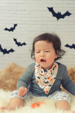 Sweet Beautiful baby girl crying on beautiful white furry.Happy halloween baby concept.