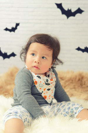 Sweet Beautiful baby girl crying on beautiful white furry.Happy halloween baby concept.の写真素材