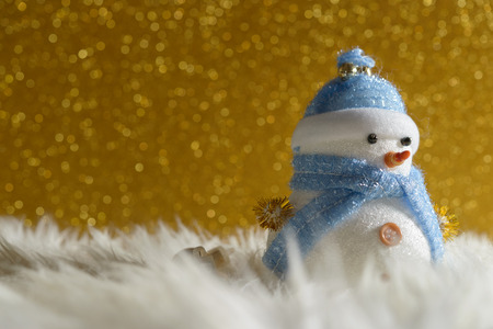 Happy snowman standing in gold winter christmas snow background. Merry christmas and happy new year greeting card with copy-space. Christmas celebration holiday background.の写真素材