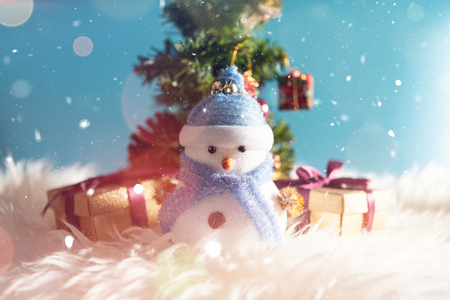 Happy snowman standing in blue winter christmas snow background. Merry christmas and happy new year greeting card with copy-space. Christmas celebration holiday backgroundの写真素材