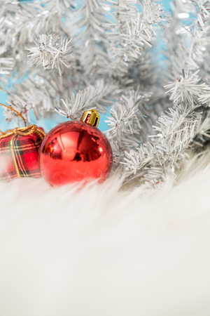 Christmas background with a red ornament gift box and fir in snow. Merry christmas and happy new year greeting card with copy-space. Christmas celebration holiday background.の写真素材