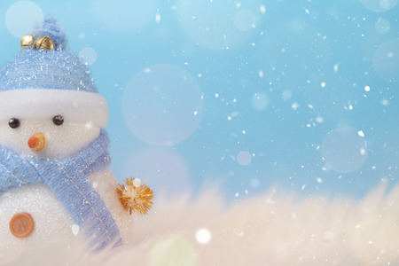 Happy snowman standing in blue winter christmas snow background. Merry christmas and happy new year greeting card with copy-space. Christmas celebration holiday background.の写真素材