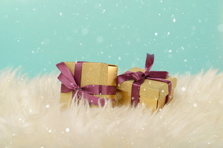 Christmas presents with purple ribbon in warm white blanket. Christmas celebration holiday background. New year and christmas celebration concept.の写真素材