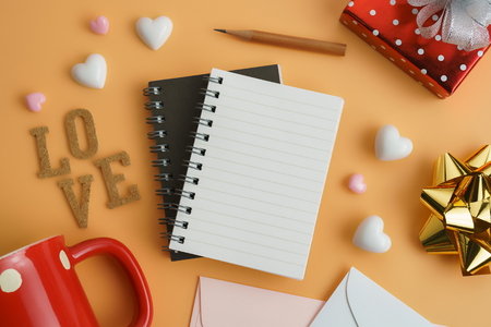 Flat view of blank notepads in the centre of valentines hearts with red gift box and coffee cup on color background with copy space. Symbol of love. Happy Valentines Day background.Saint Valentine's Day concept. Can be used for celebrations valentines day.の写真素材