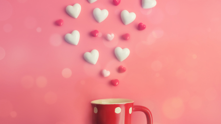 Flying hearts over red coffee cup on pink background with copy space. Symbol of love. Happy Valentines Day background.Saint Valentine's Day concept. Can be used for celebrations valentines day.の写真素材