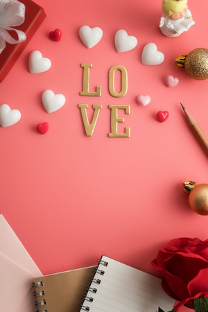 Flat view of notepads  in the centre of valentines hearts and decoration on pink background with copy space. Symbol of love. Happy Valentines Day background.Saint Valentine's Day concept.の写真素材