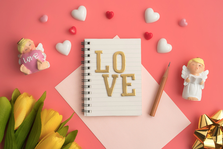 Flat view of notepads  in the centre of valentines hearts and decoration on pink background with copy space. Symbol of love. Happy Valentines Day background.Saint Valentine's Day concept.の写真素材