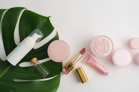 White cosmetic products and green leaves on white background. Natural beauty products for branding mock-up concept.の写真素材