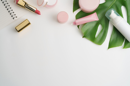 White cosmetic products and green leaves on white background. Natural beauty products for branding mock-up concept.の写真素材