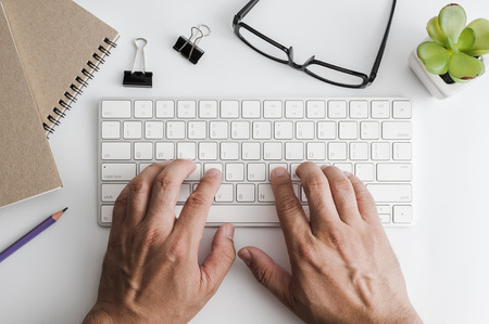 Styled stock photography white office desk table with blank notebook, computer, supplies and coffee cup. Top view with copy space. Flat lay.の写真素材
