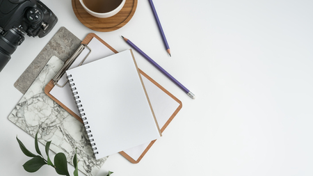 Styled stock photography white office desk table with blank notebook, computer, supplies and coffee cup. Top view with copy space. Flat lay.の写真素材