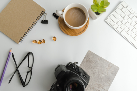 White office desk table with blank notebook, computer, supplies and coffee cup. Top view with copy space. Flat lay.の写真素材