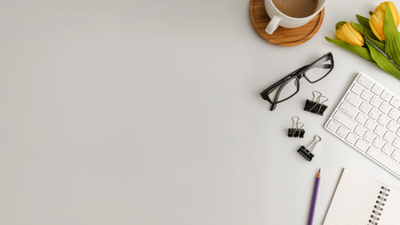 White office desk table with blank notebook, computer, supplies and coffee cup. Top view with copy space. Flat lay.の写真素材