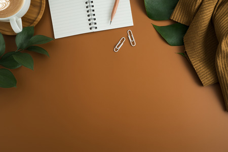 Styled stock photography brown office desk table with blank notebook, keyboard, macaroon, supplies and coffee cup. Top view with copy space. Flat lay.の写真素材