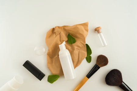 White cosmetic products and green leaves on white background. Natural beauty blank label for branding mockup concept.の写真素材