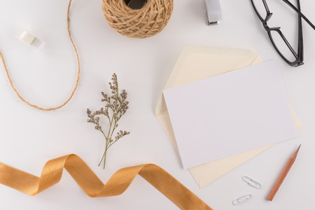 A wedding concept. Wedding Invitation, envelopes, cards Papers on white background with ribbon and decoration. Top view, flat lay, copy spaceの写真素材