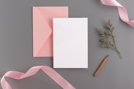 A wedding mock up concept. Wedding Invitation, envelopes, cards Papers on grey background with ribbon and decoration. Top view, flat lay, copy spaceの写真素材
