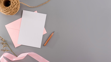 A wedding mock up concept. Wedding Invitation, envelopes, cards Papers on grey background with ribbon and decoration. Top view, flat lay, copy spaceの写真素材