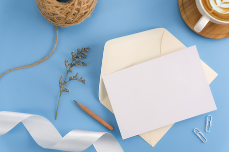 A wedding mock up concept. Wedding Invitation, envelopes, cards Papers on light blue background with ribbon and decoration. Top view, flat lay, copy spaceの写真素材