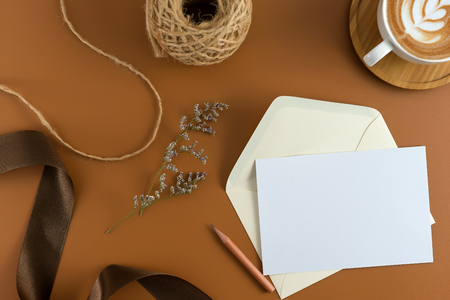 A wedding concept. Wedding Invitation, envelopes, cards Papers on brown background with ribbon and decoration. Top view, flat lay, copy spaceの写真素材