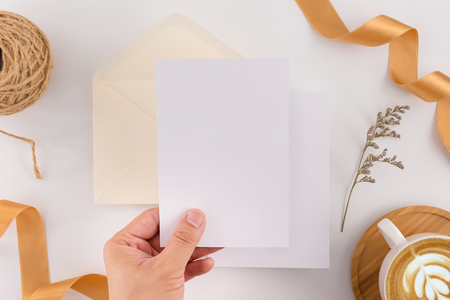 A wedding concept. Wedding Invitation, envelopes, cards Papers on white background with ribbon and decoration. Top view, flat lay, copy spaceの写真素材
