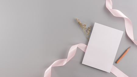 A wedding mock up concept. Wedding Invitation, envelopes, cards Papers on grey background with ribbon and decoration. Top view, flat lay, copy spaceの写真素材