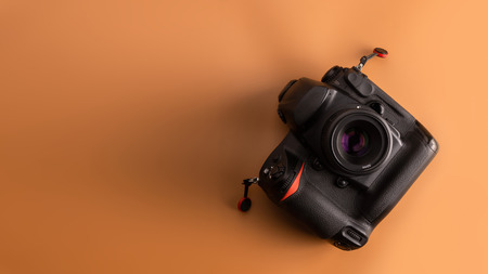 Flat lay, top view of camera on brown background.の写真素材