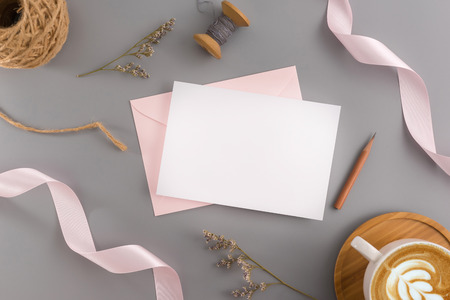 A wedding mock up concept. Wedding Invitation, envelopes, cards Papers on grey background with ribbon and decoration. Top view, flat lay, copy spaceの写真素材