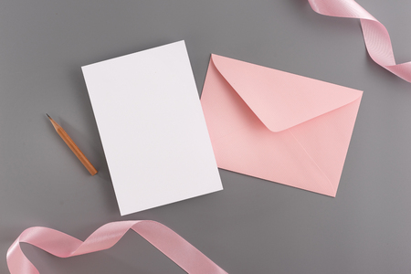 A wedding mock up concept. Wedding Invitation, envelopes, cards Papers on grey background with ribbon and decoration. Top view, flat lay, copy spaceの写真素材