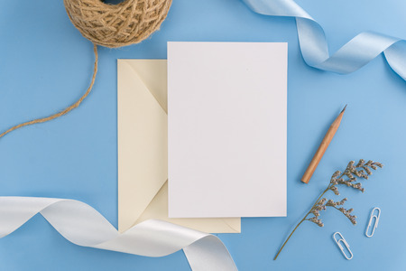 A wedding mock up concept. Wedding Invitation, envelopes, cards Papers on light blue background with ribbon and decoration. Top view, flat lay, copy spaceの写真素材