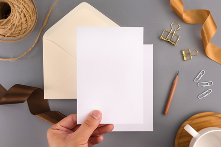 A wedding mock up concept. Wedding Invitation, envelopes, cards Papers on grey background with ribbon and decoration. Top view, flat lay, copy spaceの写真素材