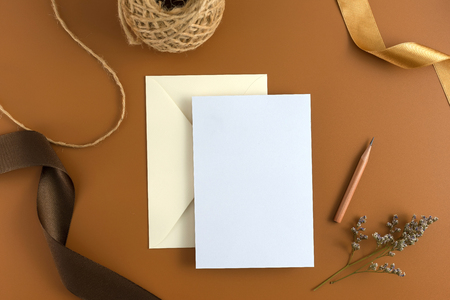 A wedding concept. Wedding Invitation, envelopes, cards Papers on brown background with ribbon and decoration. Top view, flat lay, copy spaceの写真素材