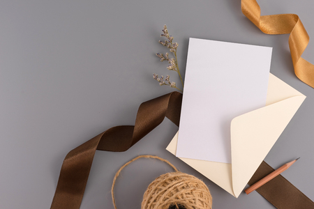 A wedding mock up concept. Wedding Invitation, envelopes, cards Papers on grey background with ribbon and decoration. Top view, flat lay, copy spaceの写真素材