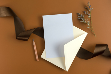 A wedding concept. Wedding Invitation, envelopes, cards Papers on brown background with ribbon and decoration. Top view, flat lay, copy spaceの写真素材