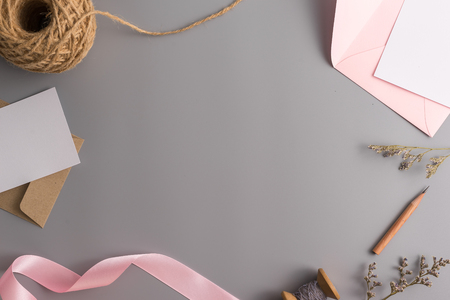 A wedding mock up concept. Wedding Invitation, envelopes, cards Papers on grey background with ribbon and decoration. Top view, flat lay, copy spaceの写真素材