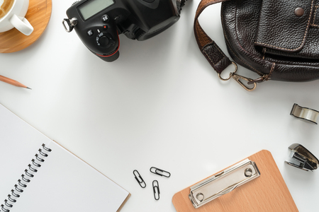 Traveler accessories, leather bag, coffee cup, notepad, camera  and passport on white background with copy space.Travel vacation concept. Flat lay, top view.の写真素材