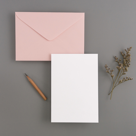 A wedding mock up concept. Wedding Invitation, envelopes, cards Papers on color background with ribbon and decoration. Top view, flat lay, copy spaceの写真素材