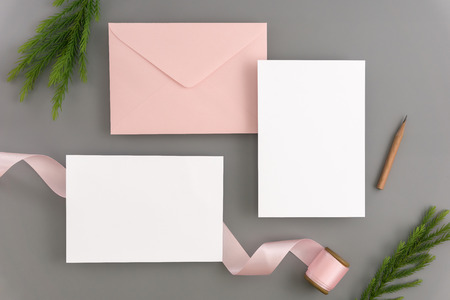 A wedding mock up concept. Wedding Invitation, envelopes, cards Papers on color background with ribbon and decoration. Top view, flat lay, copy spaceの写真素材