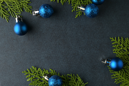 Christmas background template with frame of fir branches and christmas ornament in blue texture background. Flat lay, top viewの写真素材