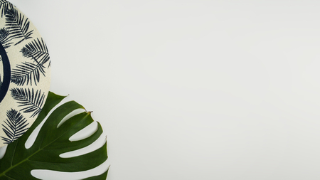 Flat lay, top view workspace with eye glasses, notebook, hat, pencil, green leaf, shoes and coffee cup on white background. Summer stylish traveller blogger concept.の写真素材