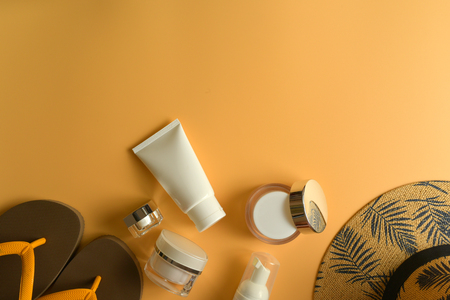 Flat lay, top view workspace with eye glasses, notebook, hat, sun block, shoes and coffee cup on yellow background. Summer stylish traveller blogger concept.の写真素材